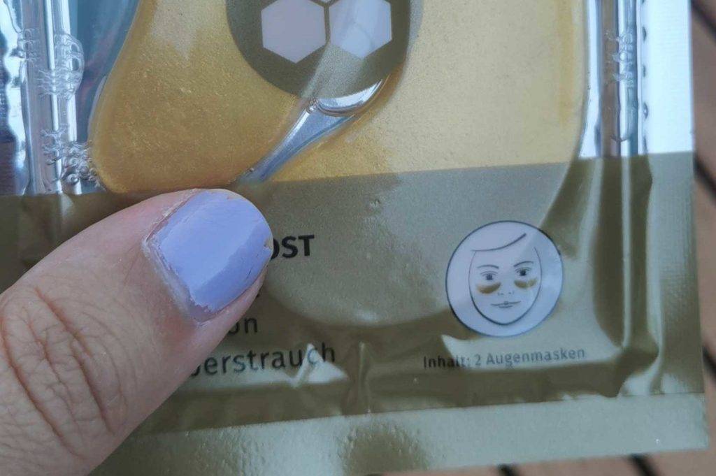 Verpackung von Augenpads in der Hand.