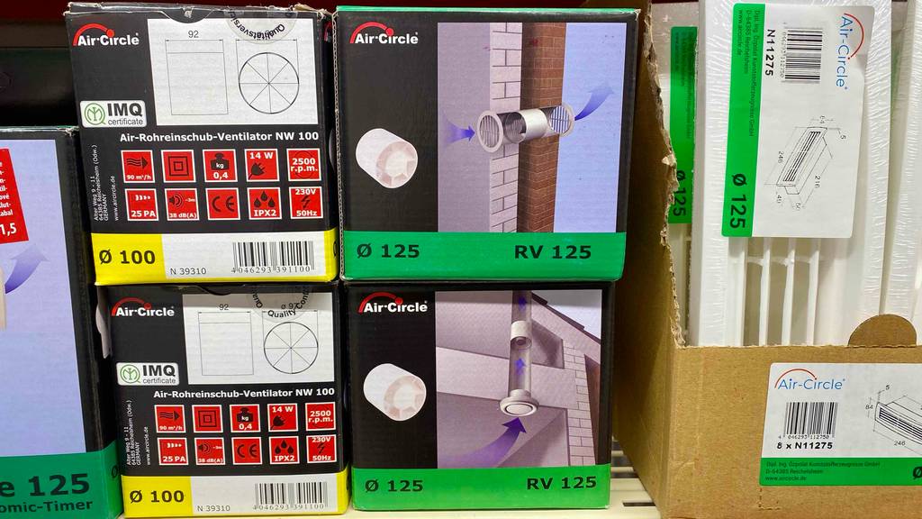 In einem Verkaufsregal neben anderen Produkten steht ein getesteter Rohrventilator in Originalverpackung.