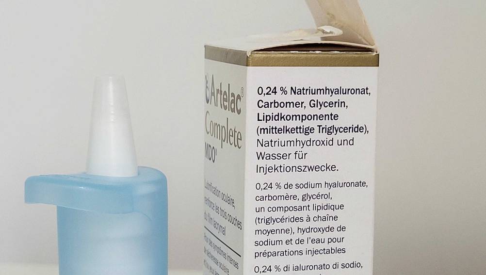 Im Test: Nahaufnahme Dosierer neben einer Verpackung von der Seite von Allergie-Augentropfen.