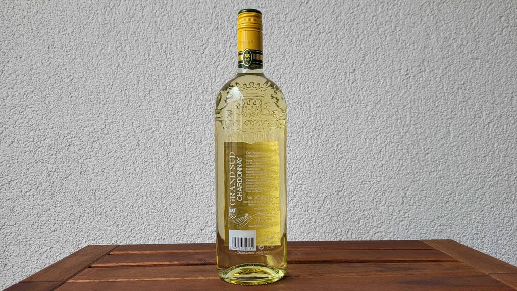 Weißwein getestet: Rückseite einer Weißweinflasche, die auf einem Tisch steht.
