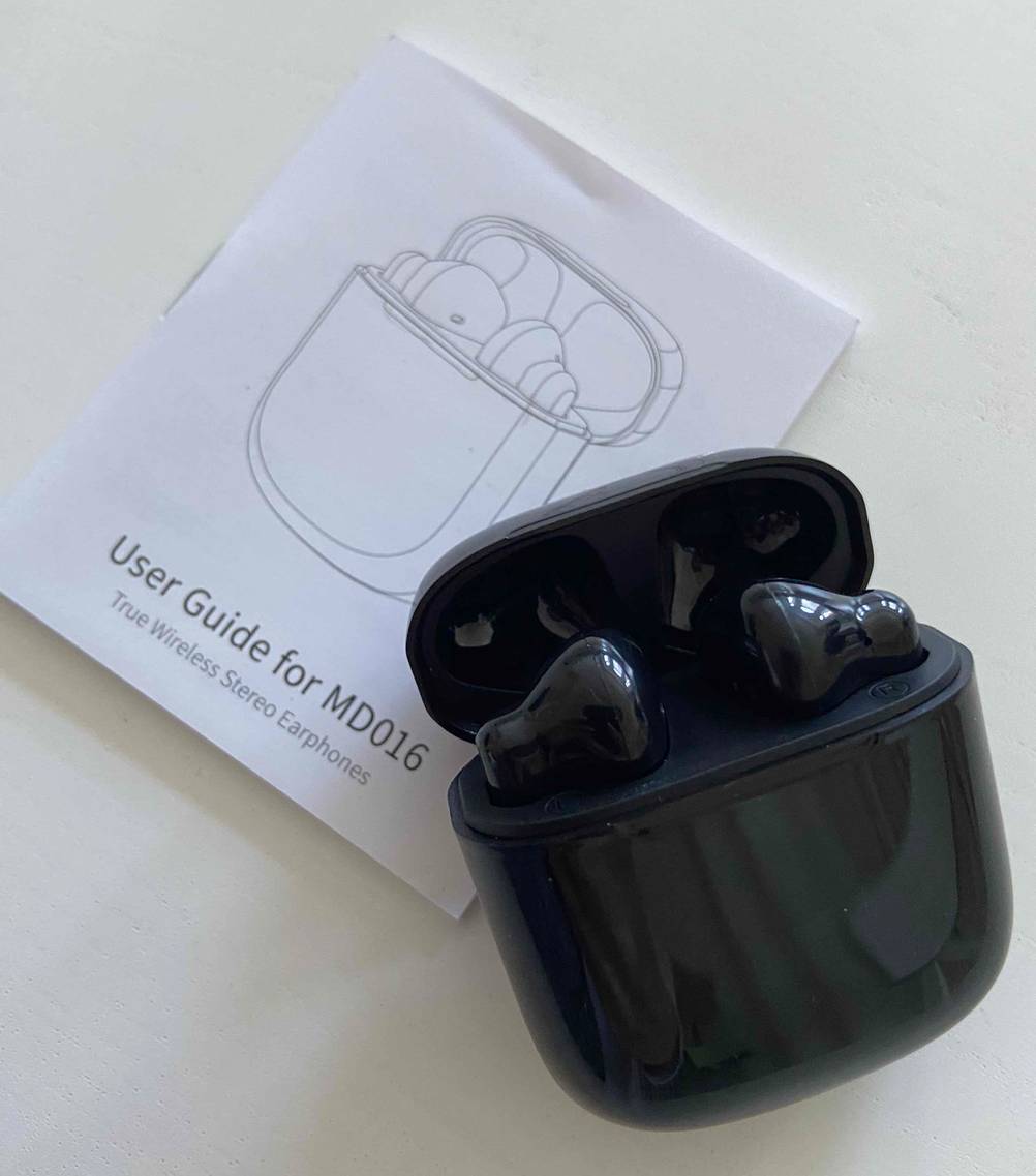 In-Ear-Kopfhörer-Test: geöffnetes Case von Kopfhörern liegt auf der Gebrauchsanweisung.