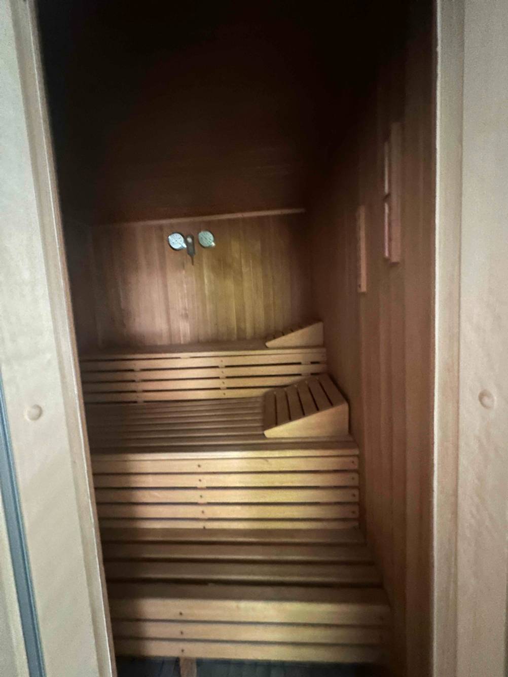 Innenansicht einer getesteten Sauna mit Kopferhöhung auf der Bank platziert.
