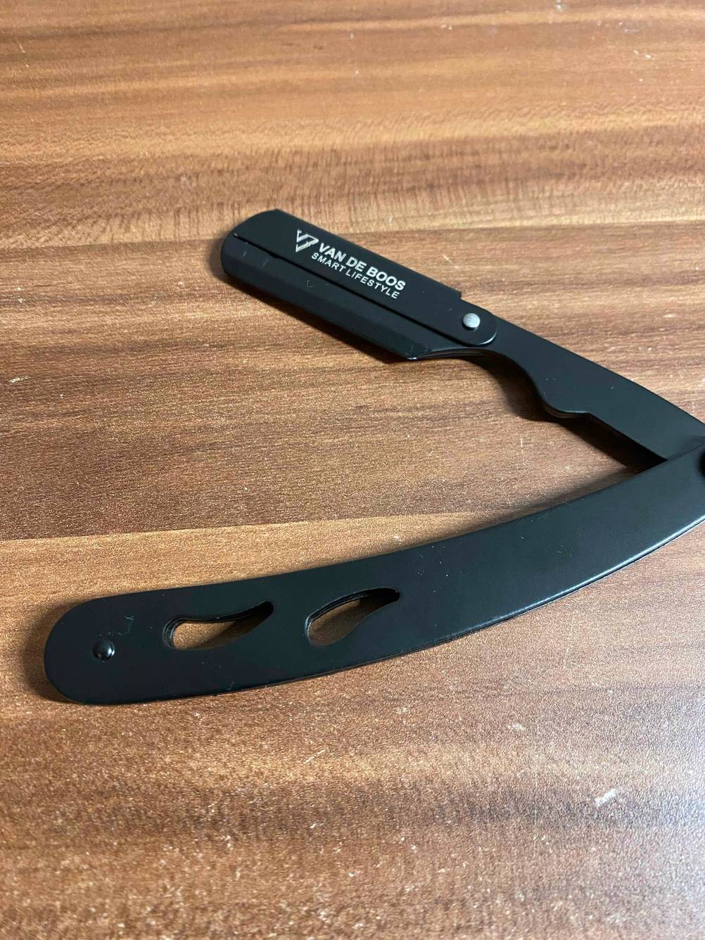 Rasiermesser-Test: Auf einer Holzfläche liegt ein aufgeklapptes Rasiermesser.