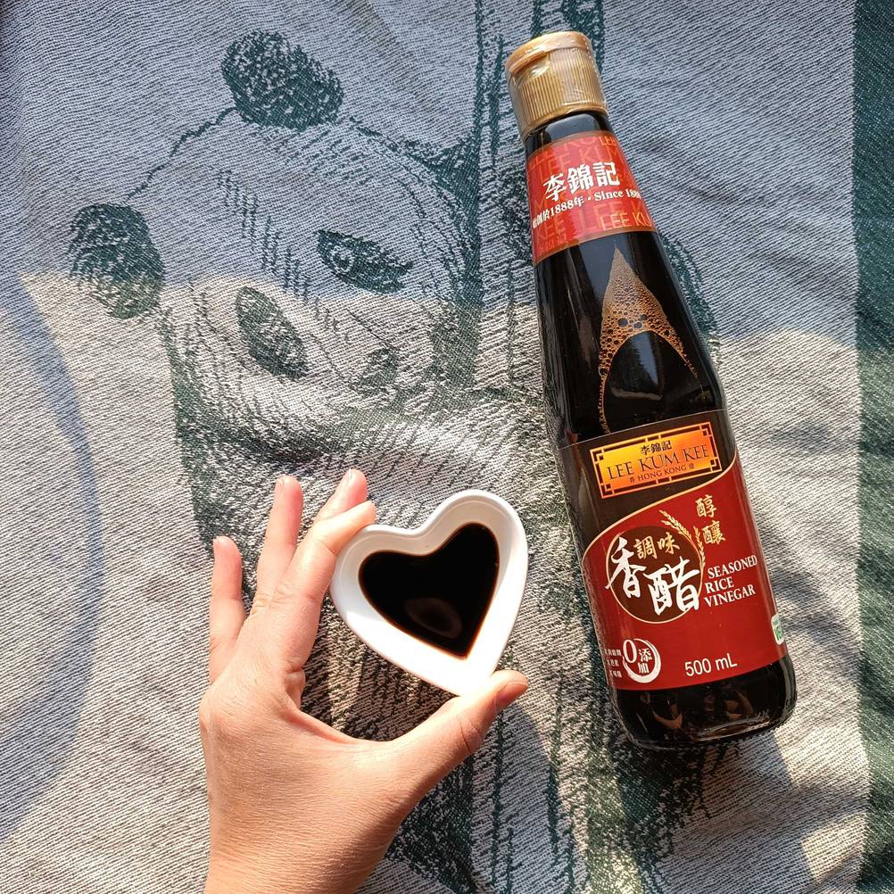 Reisessig in Flasche und in einer Schüssel.