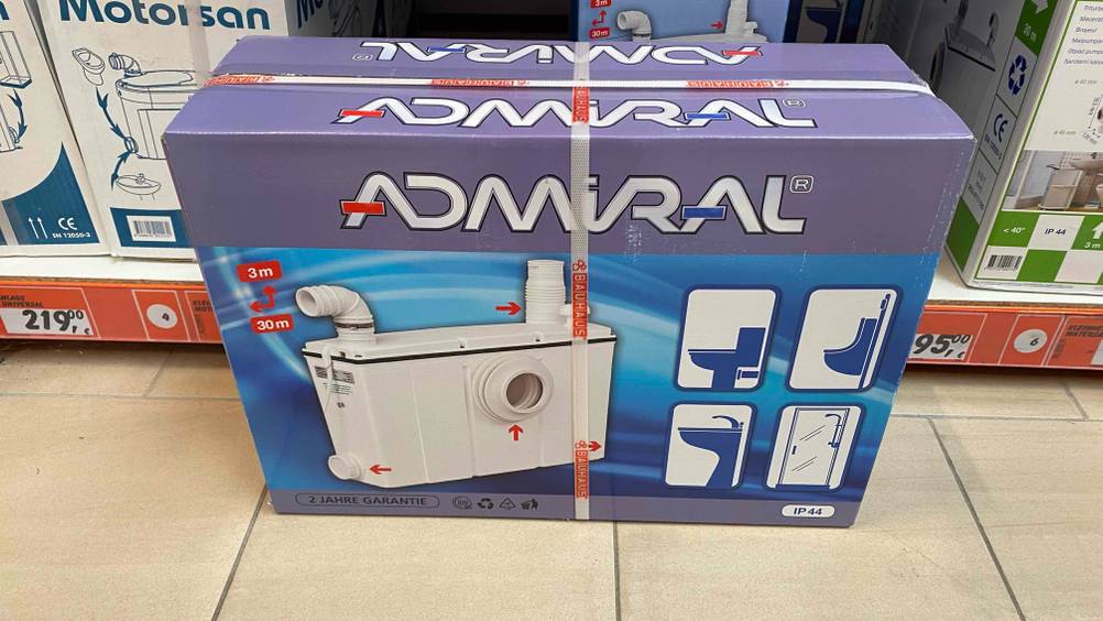 Hebeanlage getestet: Eine verpackte Anlage steht vor einem Regal auf einem Fließenboden.
