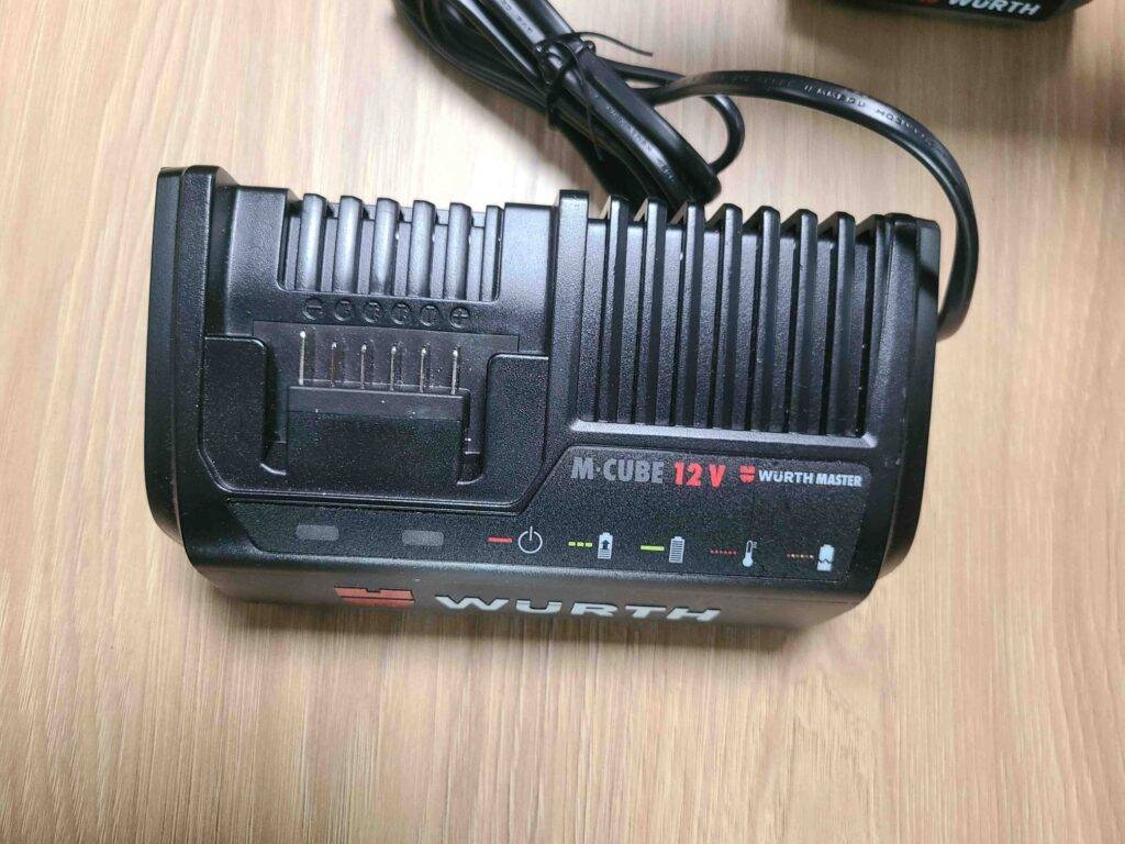 Ansicht des auf einer Holzoberfläche liegenden Ladegeräts von dem getesteten 12V-Akkuschrauber.