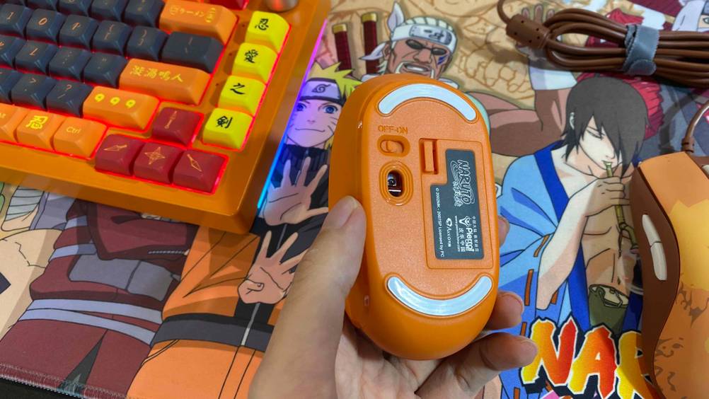 Eine Hand hält eine getestete Bluetooth-Gaming-Maus mit der Rückseite nach oben.
