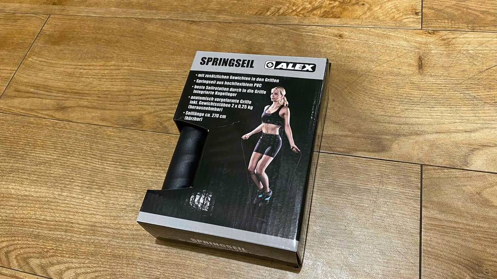 Springseil getestet: Springseil mit Gewichten in den Griffen in Verpackung liegt auf einem Boden. 