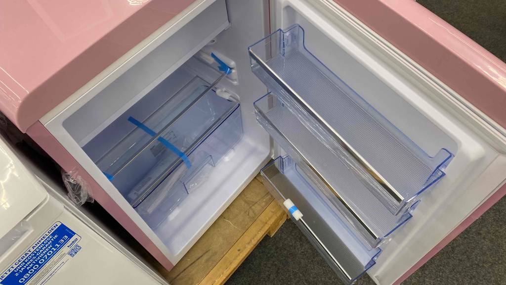 Amica-Kühlschrank getestet: Amica-Kühlschrank geöffnet von oben fotografiert, mit Betriebsanleitung im Gemüsefach liegend.