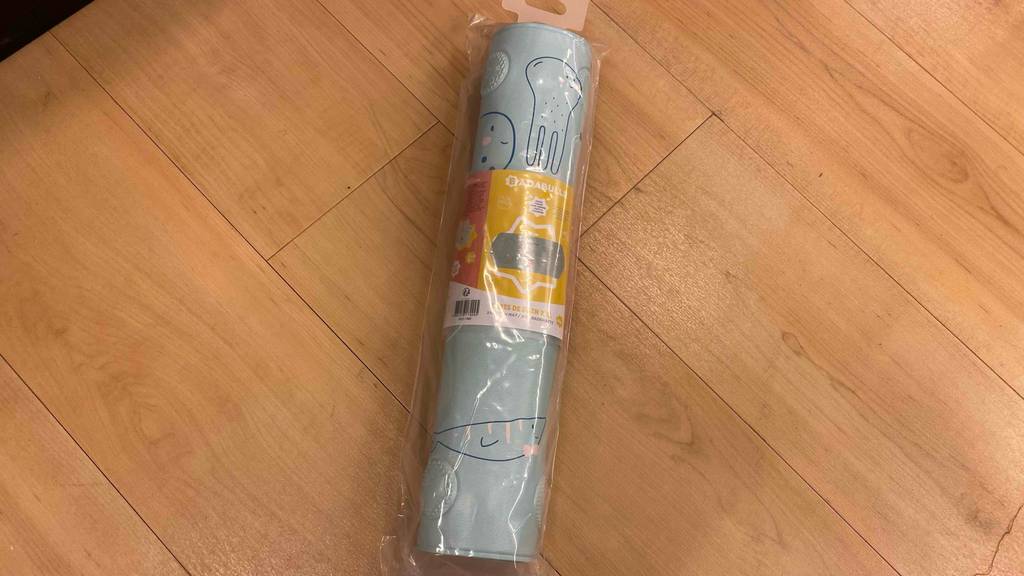 Badewannenmatte-Kinder getestet: Badewannenmatte für Kinder eingerollt liegend auf einem Holzboden.