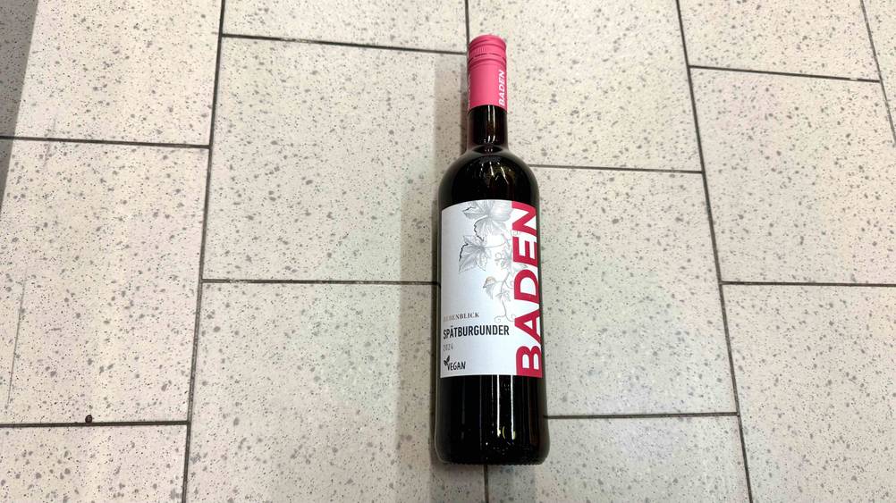 Eine Flasche Spätburgunder der getestet wurde liegt auf einem Boden.