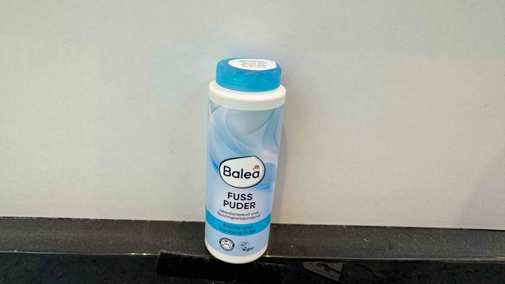 Ein getestetes Fußpuder von Balea steht vor einer weißen Wand.
