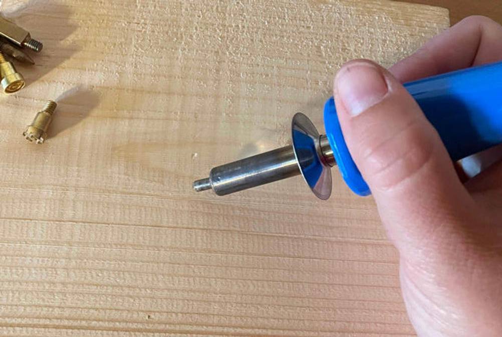 Brandmalkolben in der Hand und Holz zu sehen.