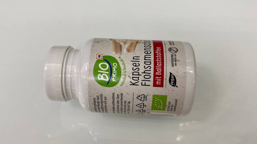 Flohsamenschalen-Kapseln getestet: Eine Packung liegt quer auf hellem Untergrund