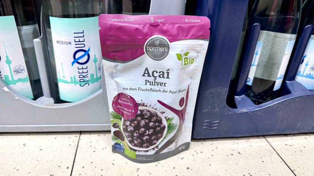 Das getestete Acai-Pulver steht vor Getränkekisten.