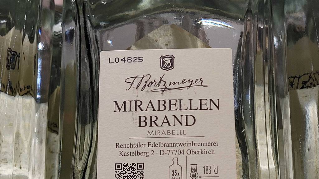 Mirabellenschnaps-Test: Nahaufnahme der Produktinformationen auf dem Etikett einer transparenten Glasflasche.