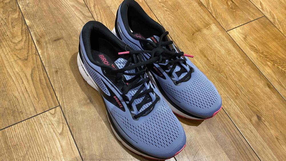 Brooks-Laufschuhe im Test: ein Paar blaue Laufschuhe auf einem Holzboden stehend.
