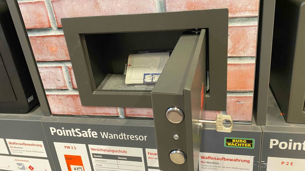 Wandtresor im Test: ein geöffneter Wandtresor mit Schlüssel in einem Geschäft ausgestellt.