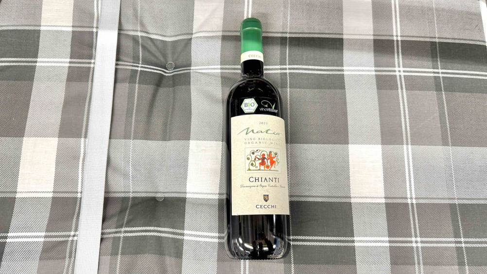 Test: Eine Flasche Chianti liegt auf einer Polsterung.