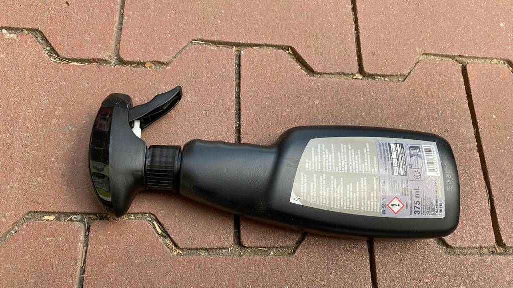 Flugrostentferner getestet: Eine Flasche liegt mit der Rückseite nach oben auf einem Steinboden