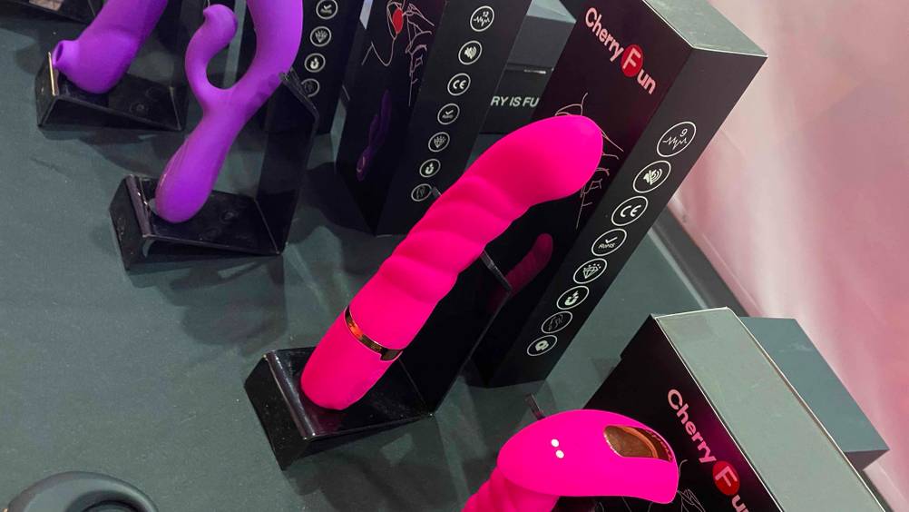 Auf einer Austellungsfläche steht neben anderen Produkten ein getesteter Dildo.