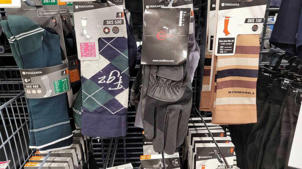 Reithandschuhe-Test: Getestete Reithandschuhe hängen in einem Regal neben verschiedenen Paar Socken.