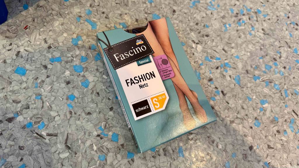 Eine Packung der getesteten Netzstrumpfhose in der Größe S liegt auf einem Boden.