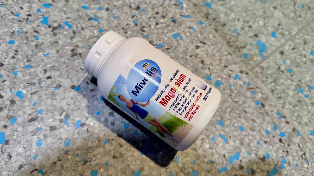 Eine Packung getestete Magnesium-Tabletten von Mivolis liegt auf einem grauen Boden.
