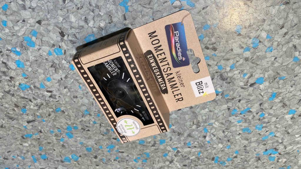 Einwegkamera liegt getestet und verpackt auf einem Boden.
