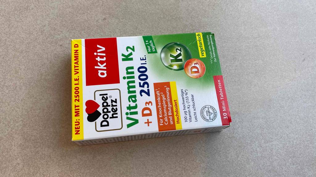 Vitamin-K12-Test: Verpackung von Vitamin-K12-Tabletten der Marke Doppelherz liegt horizontal auf einem Boden.