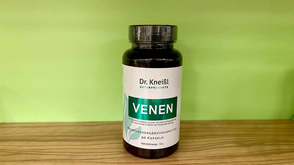 Venen Tabletten getestet: Eine Packung steht vor grünem Hintergrund auf Holzoberfläche