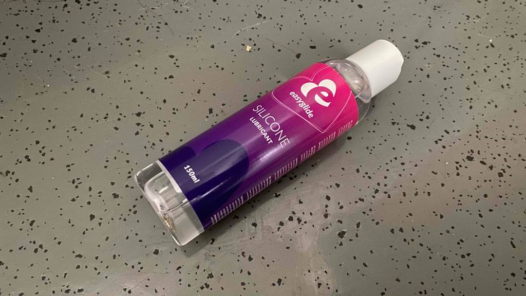 Silikon-Gleitgel getestet: Auf einer grauen Fläche liegt quer eine Flasche.