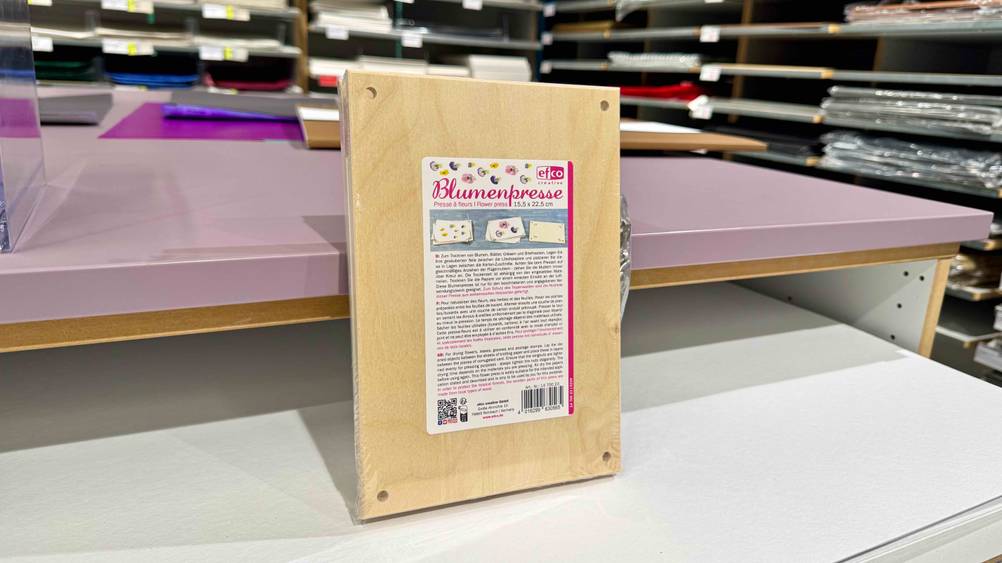 Die getestete Blumenpresse aus Holz steht vertikal auf einem Tisch.