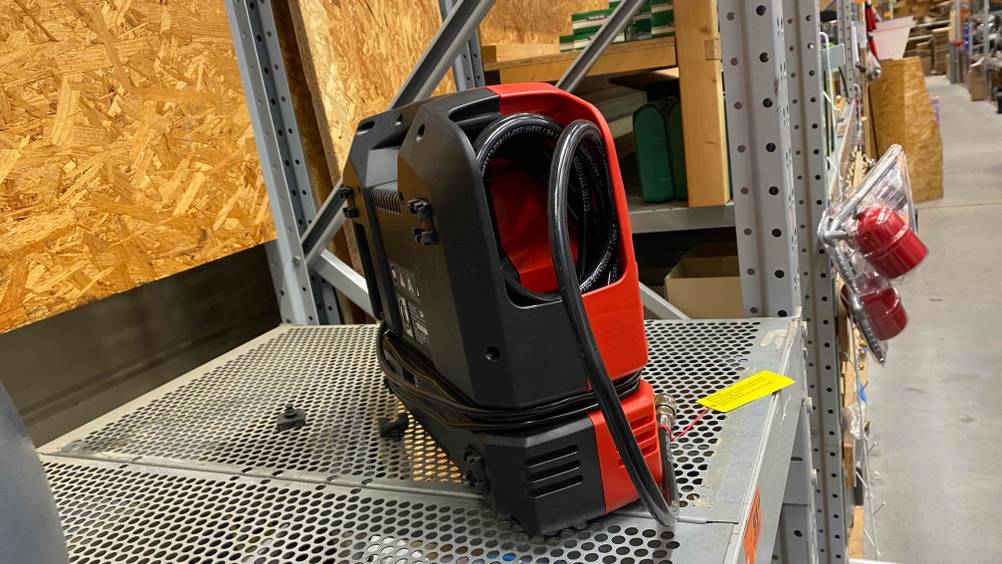 Tragbarer-Kompressor im Test: ein Kompressor von der Seite mit eingerolltem Kabel darin.
