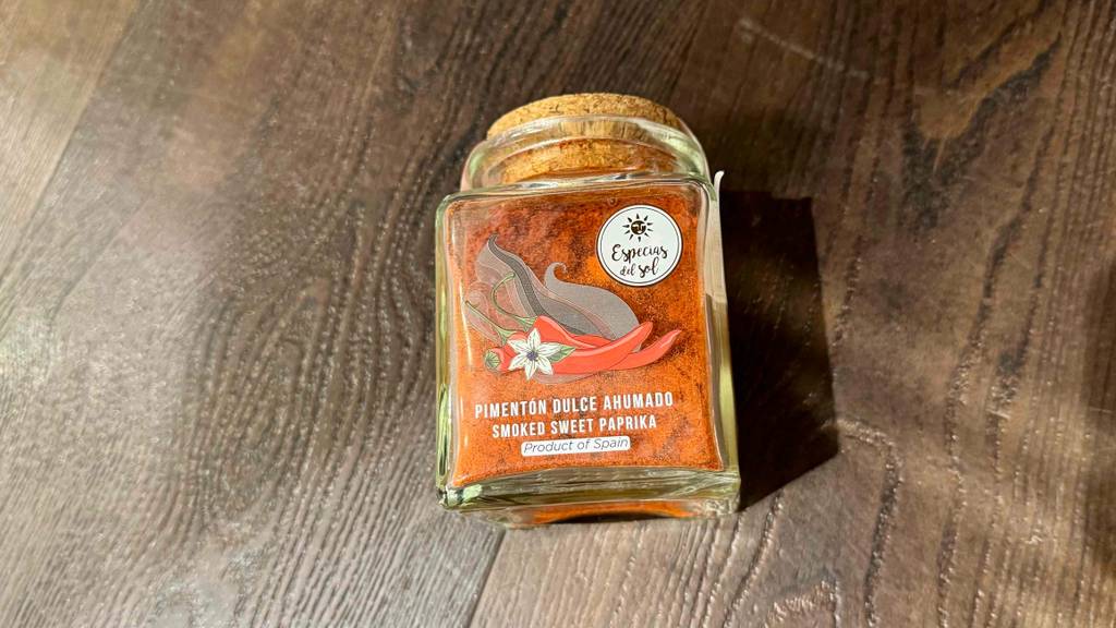 Das getestete geräucherte Paprikapulver liegt in der Glasverpackung auf einer Holzfläche.