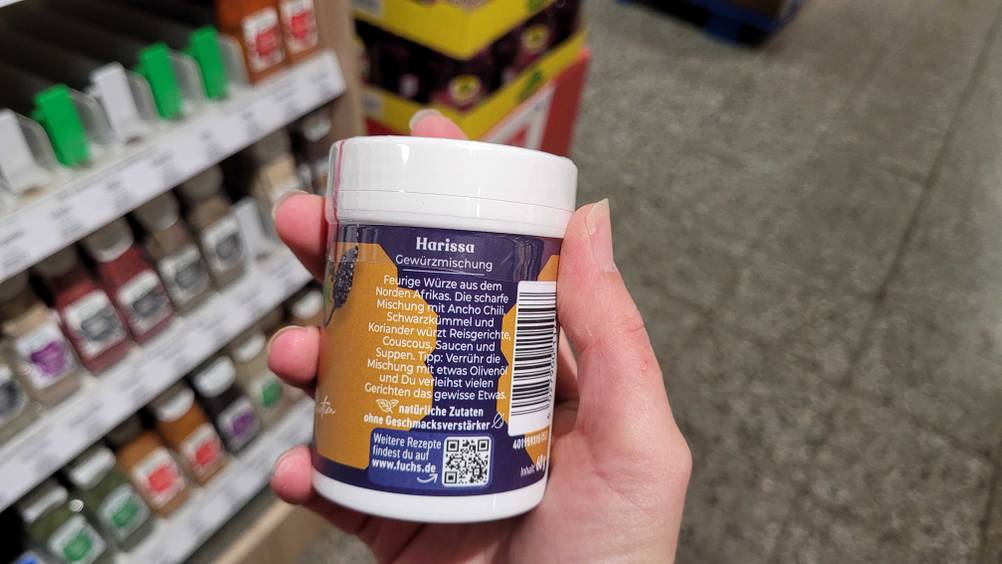 Im Test: Eine Hand hält eine Dose Harissa mit der Rückseite nach vorne.