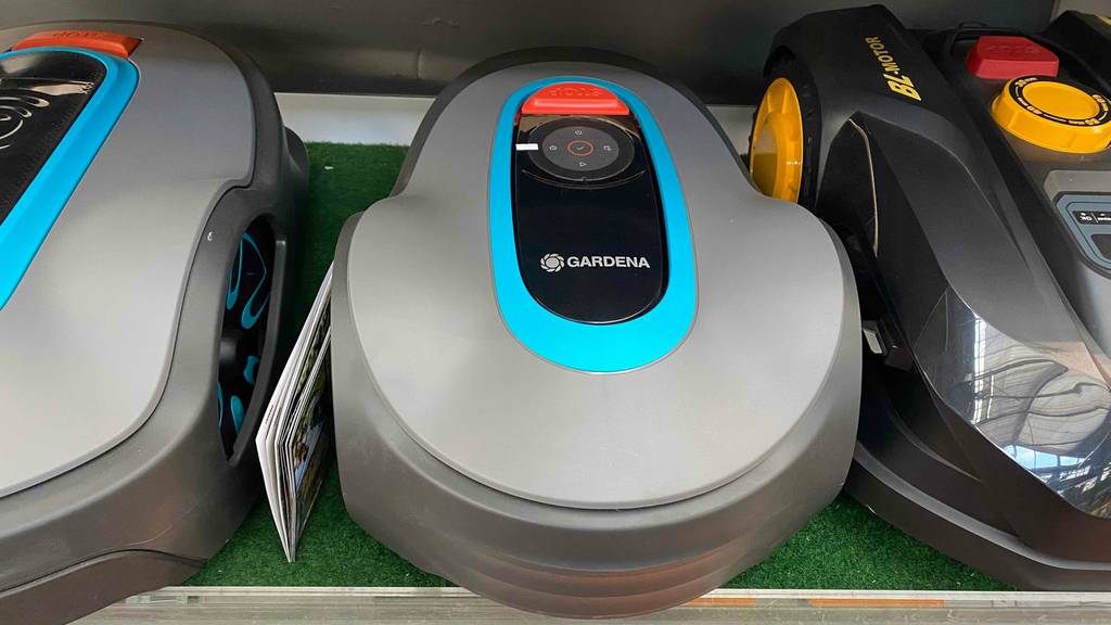 Gardena-Mähroboter-Test: Mähroboter steht neben anderen Mährobotern in einem Regal.