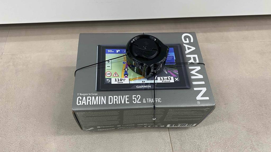Auf einem Fließenboden liegt ein getestetes Navigationsgerät von garmin in seiner Verpackung.