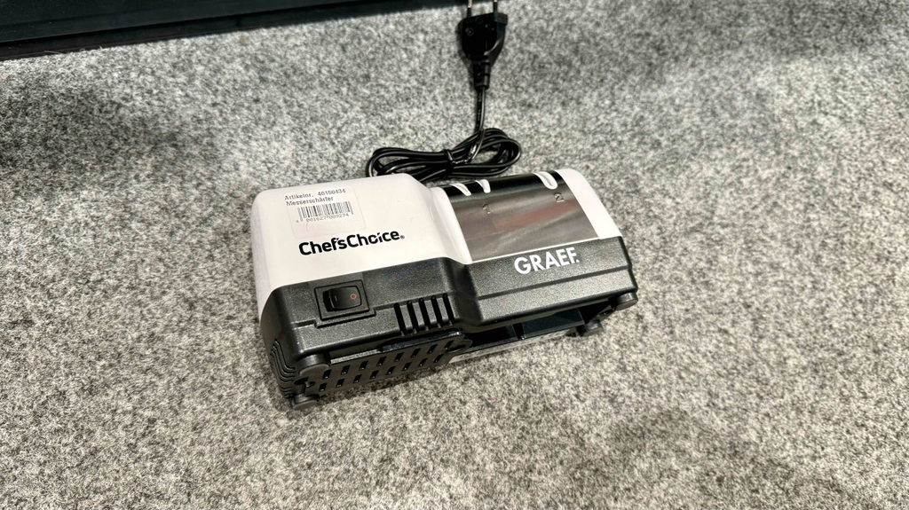 Test: der elektrische Messerschärfer liegt auf einer grauen Fläche mit dem Ein- und Ausschalter ersichtlich.