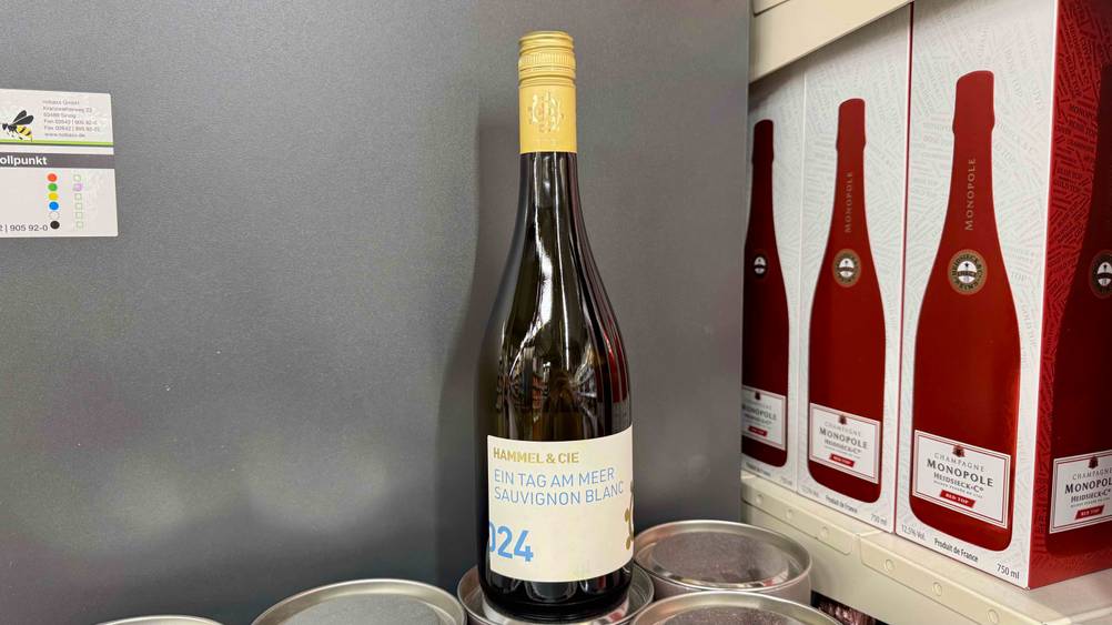 Der getestete Sauvignon-Blanc steht vor einer grauen Wand.