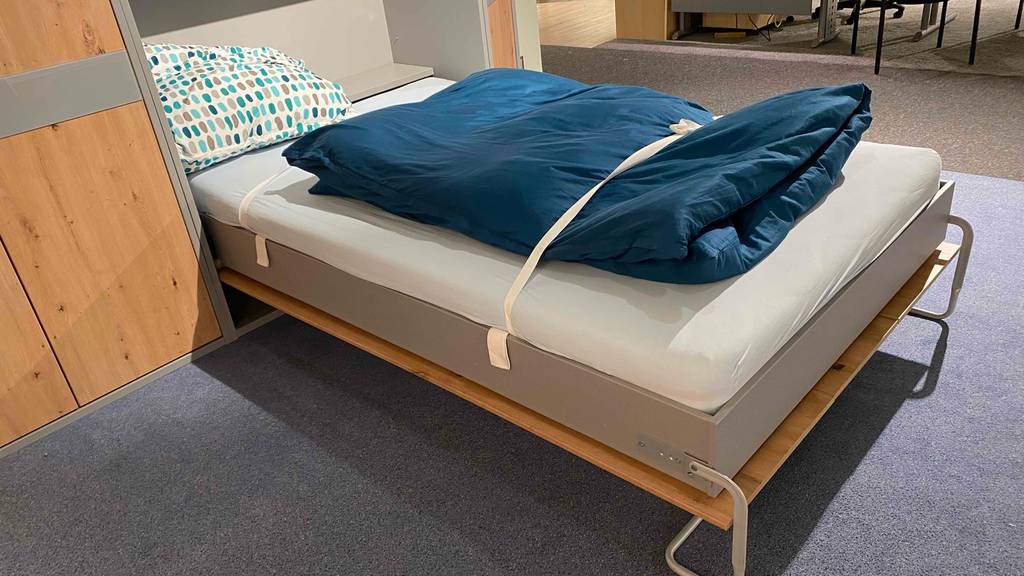 Schrankbett im Test: ein Schrankbett mit Blick auf das Bett, bei welchem die Bettwäsche mit Bändern gesichert ist.