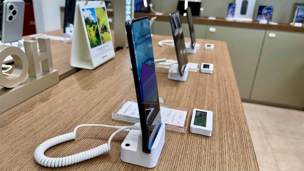 Das Smartphone bis 250 Euro im Test, von der Seite betrachtet, steht in einem Verkaufsbereich neben weiteren Smartphones.