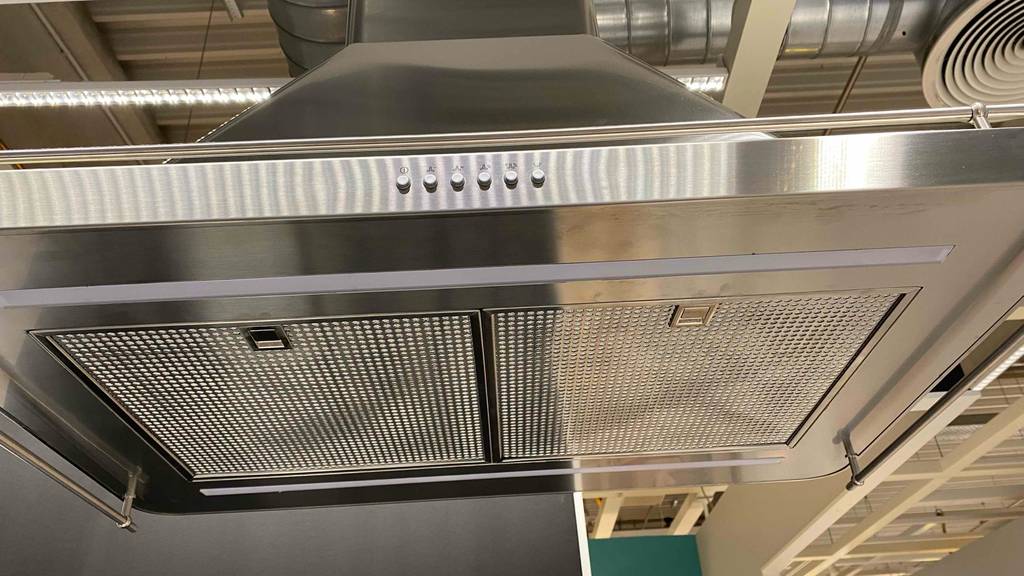 Dunstabzugshaube-90-cm im Test: das Gitter und verschiedene Knöpfe einer Dunstabzugshaube ersichtlich.
