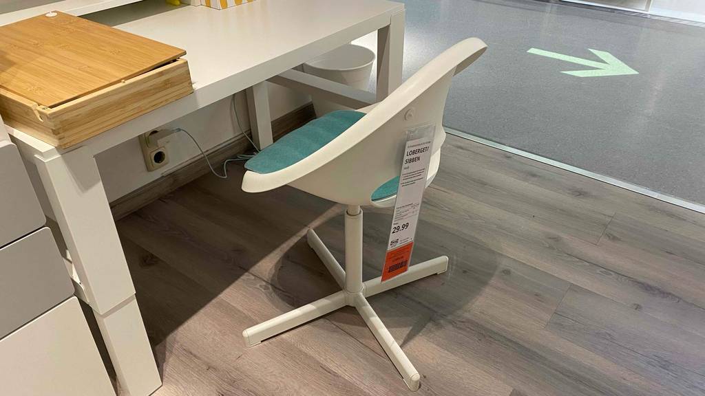 Kinderschreibtischstuhl getestet: Auf einem Holzboden vor einem Schreibtisch steht ein Kinderschreibtischstuhl.