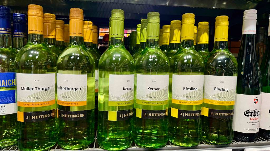 Mehrere Flaschen des getesteten Kerner-Weins stehen in einem Regal neben anderen Weinsorten.