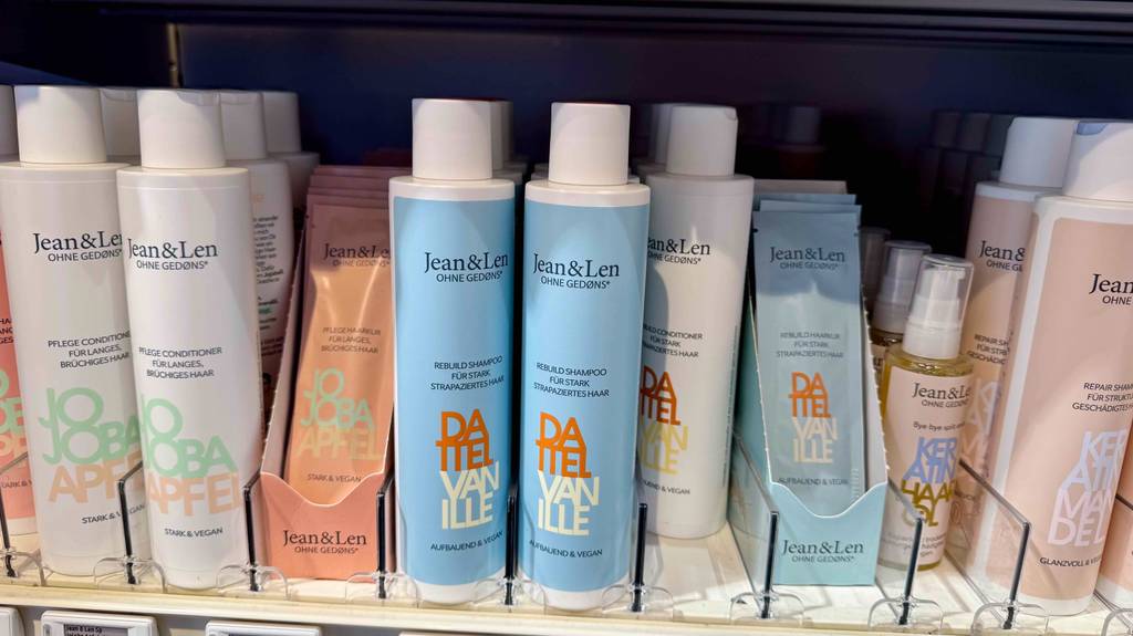 Mehrere getestete Jean-and-Len-Shampoos stehen in einem Regal.
