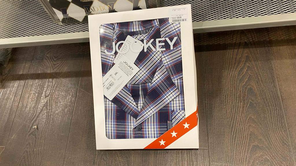 Pyjama für Herren getestet: Ein verpacktes Produkt lehnt an einem Regal.