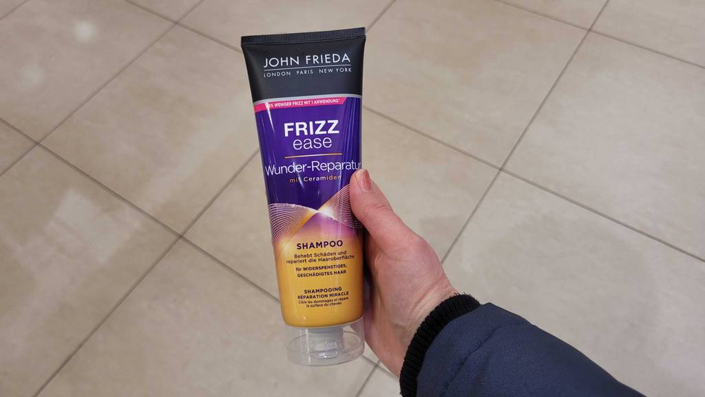 Das getestete John-Frieda-Shampoo wird in der Hand gehalten.
