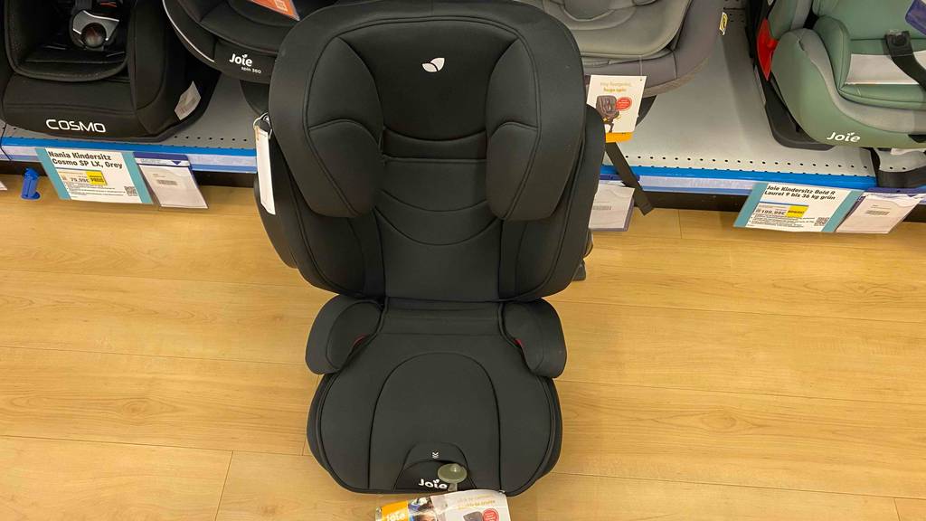 Ein getesteter Kindersitz 15–36 kg steht vor einem Verkaufsregal.