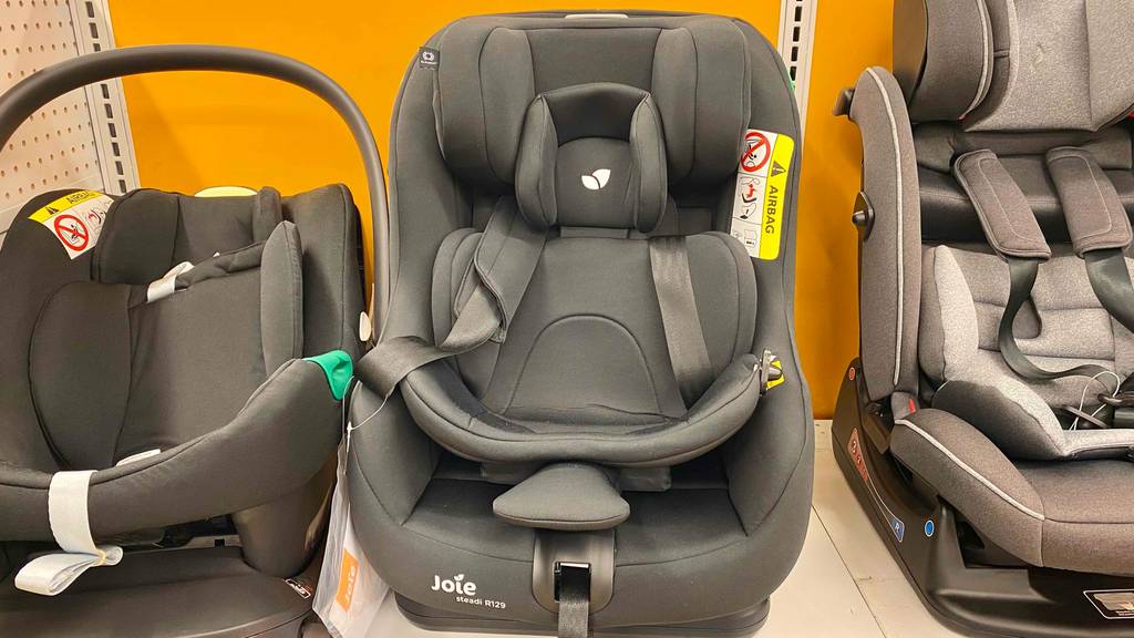 In einem Regal neben anderen Produkten steht ein getesteter Kindersitz bis 4 Jahre.
